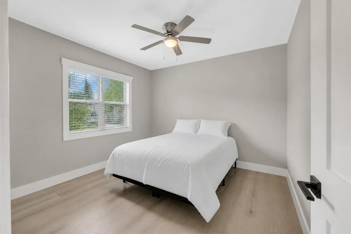 Same bedroom after interior painting in soft greige with bright white trim in Palm Bay, FL